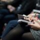 selective focus photography of people sitting on chairs while writing on notebooks